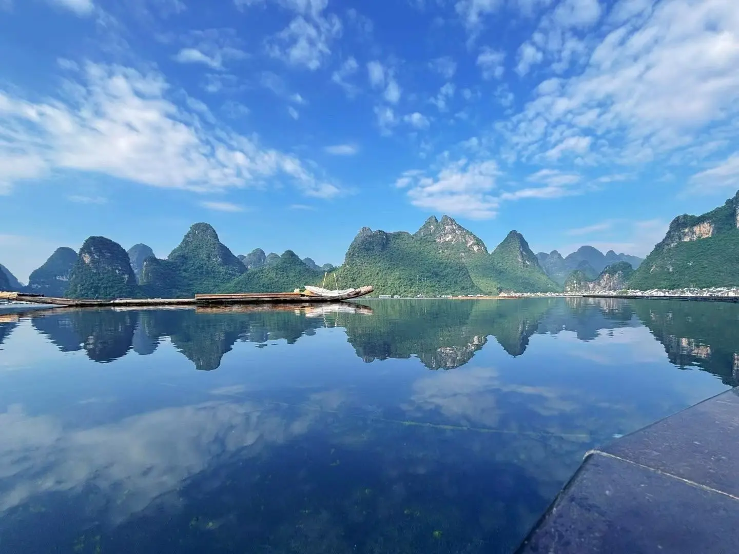 Yulong River bamboo raft under green karst hills