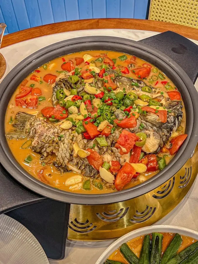 A steaming plate of Yangshuo Beer Fish with tomatoes and chili